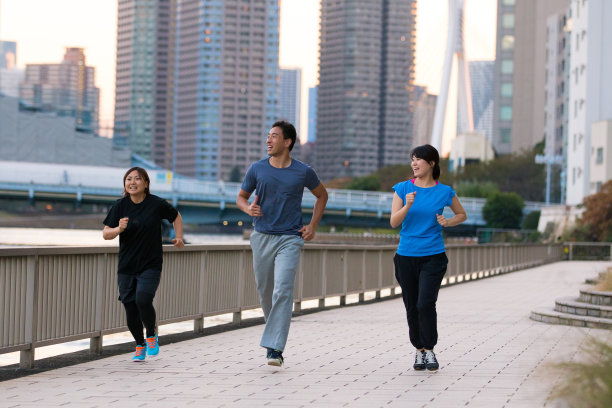 三个年轻的运动员在河边跑步图片下载
