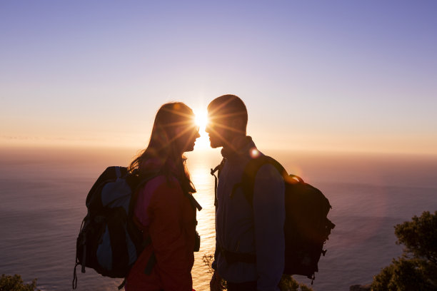 快乐的夫妇跑过阳光照耀的山图片下载