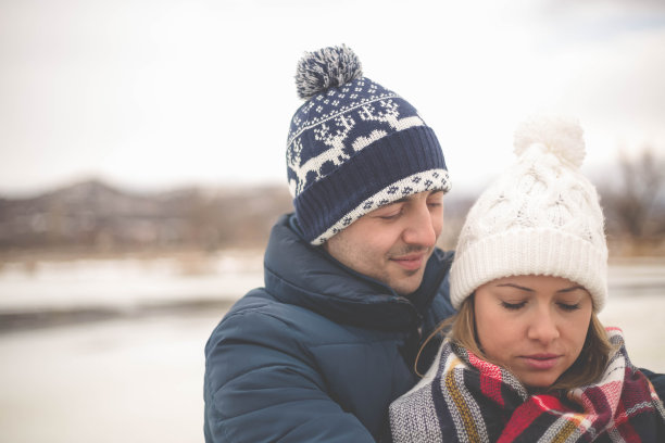 情侣们在清澈的蓝天下拥在湖边图片下载