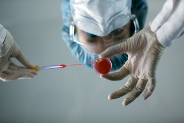 发网研究员用红色液体在移液管上工作图片下载