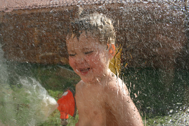 男孩玩洒水喷头图片下载