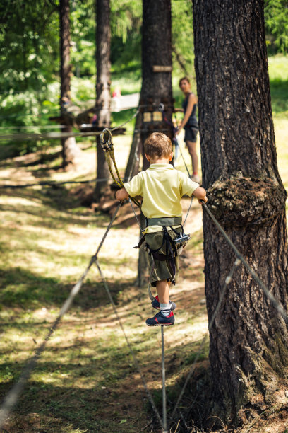 男孩在冒险公园爬山图片下载