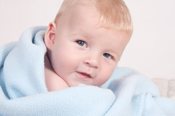 蓝色毯子里有个金发碧眼的婴儿图片下载