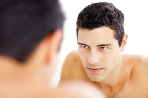 一个可爱的年轻人看着自己的倒影图片下载