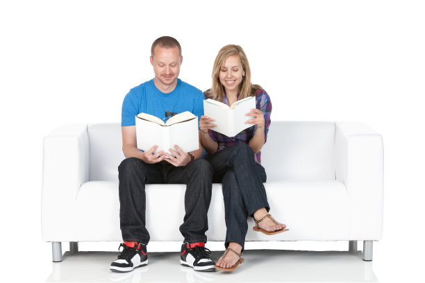 一对夫妇坐在沙发上看书图片下载