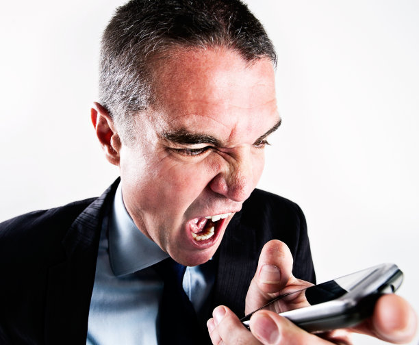愤怒的商人低头看着手机喊道图片下载