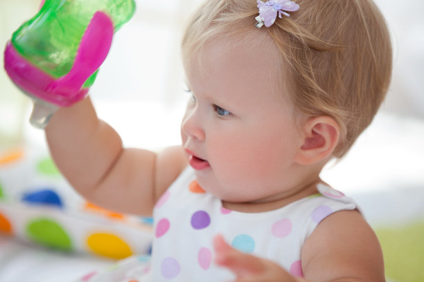 可爱的宝宝玩杯子。素材图片