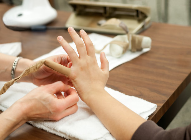 物理治疗师包扎病人的手指以控制肿胀图片下载