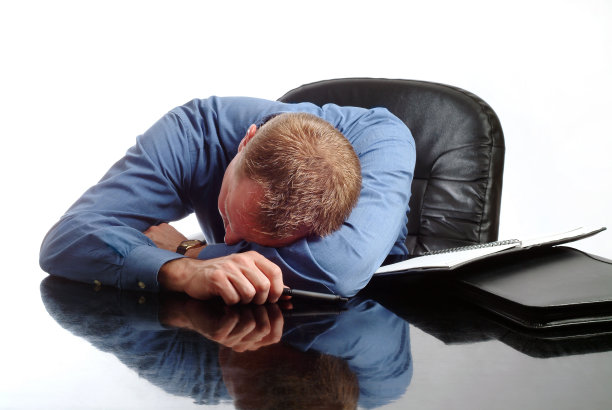 疲惫的商人在办公桌前睡着图片下载