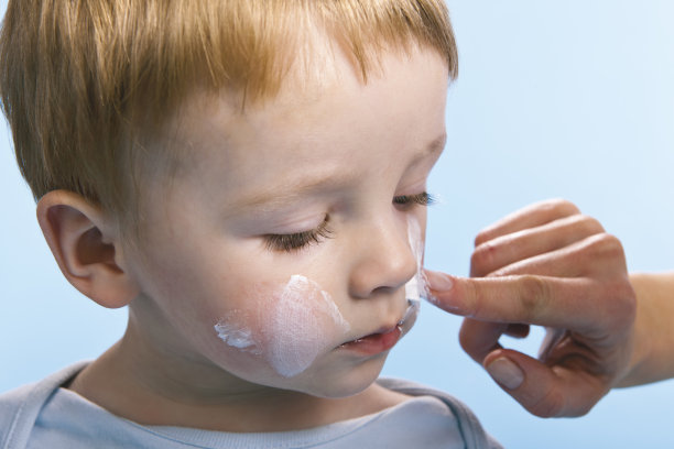 护理婴儿-在脸上涂抹乳霜图片下载