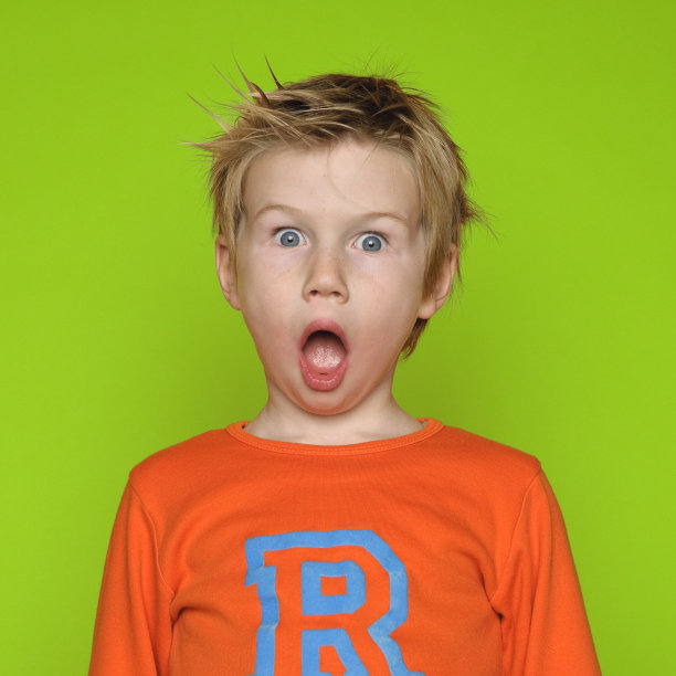 震惊的男孩在绿色背景图片下载