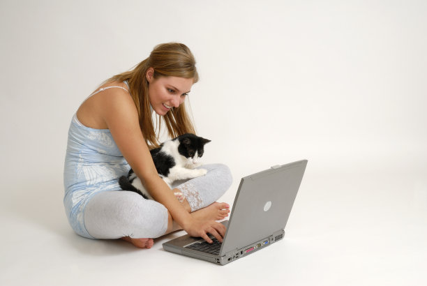 美丽的年轻女人和猫看笔记本电脑图片下载
