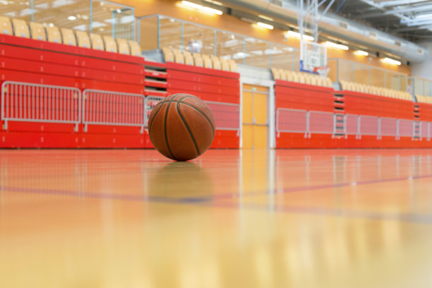 红色体育馆的拼花地板上的篮球图片下载