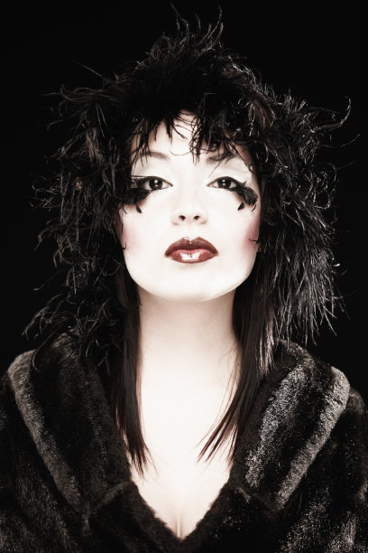 眼睛下面有羽毛和毛皮大衣的女人。孤立的图片下载