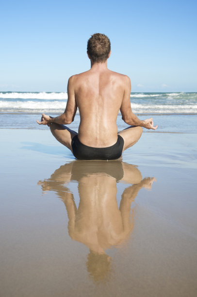 一名男子面朝大海坐着做瑜伽图片下载
