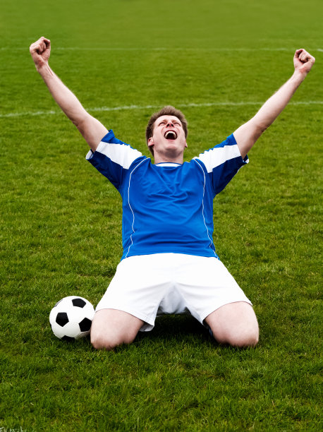 快乐的足球运动员举起双手庆祝胜利图片下载