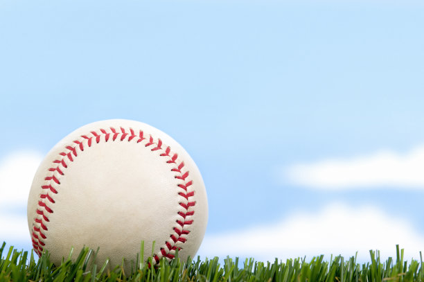 蓝天下的草地上的新棒球图片下载