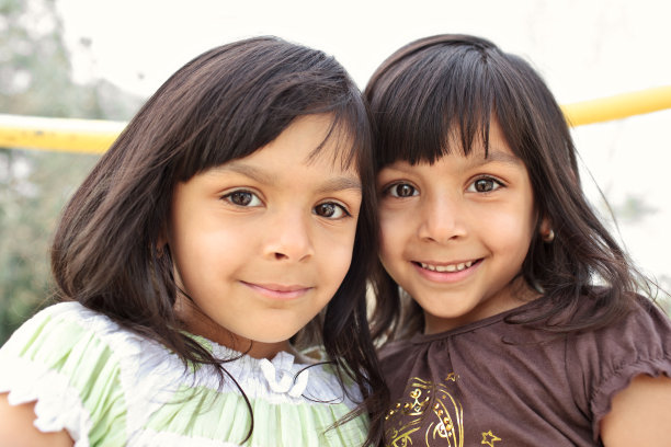一对印度双胞胎姐妹对着镜头微笑图片下载