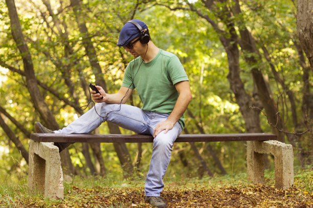 微笑随意的家伙在手机上听音乐图片下载