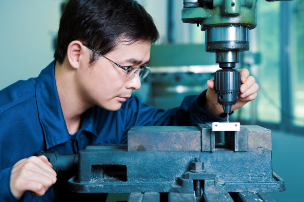 工厂工人在使用钻床图片下载