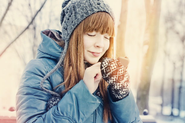 女孩在冬天的户外使用智能手机图片下载