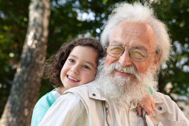 可爱的女孩拥抱着胡子祖父图片下载