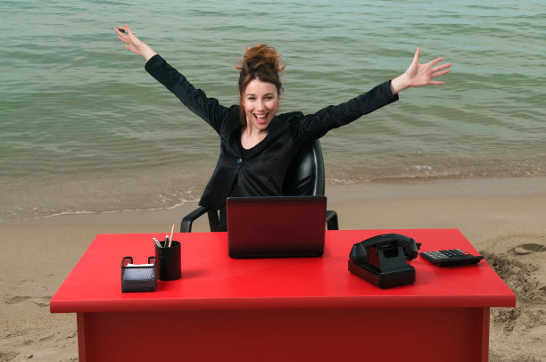 在海滩上工作的女商人图片下载