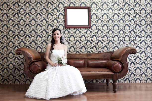 微笑的年轻新娘坐在沙发上图片下载