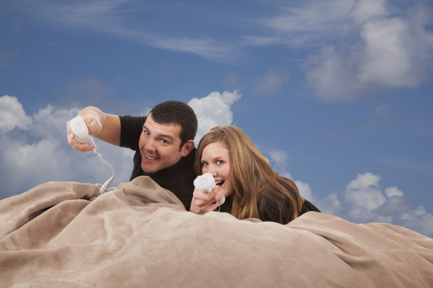 一对年轻夫妇在沙发上玩电子游戏图片下载