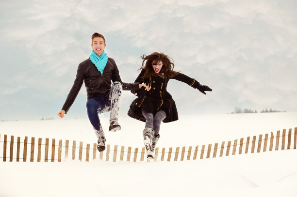 时髦的年轻夫妇在雪中玩耍图片下载