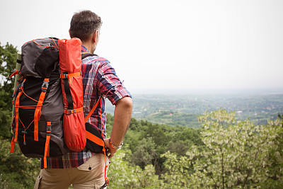 一个成熟的男人在森林里徒步旅行。素材图片