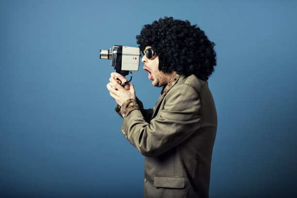 一名男子用复古相机拍下了一段视频，看起来很惊讶素材图片