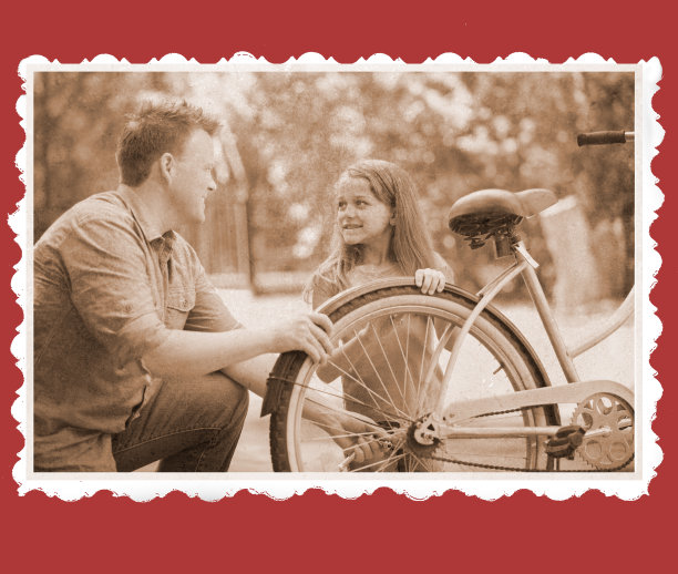 父亲帮助女儿修理自行车的复古照片。图片下载