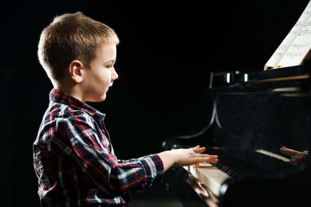 男孩在弹钢琴。图片下载