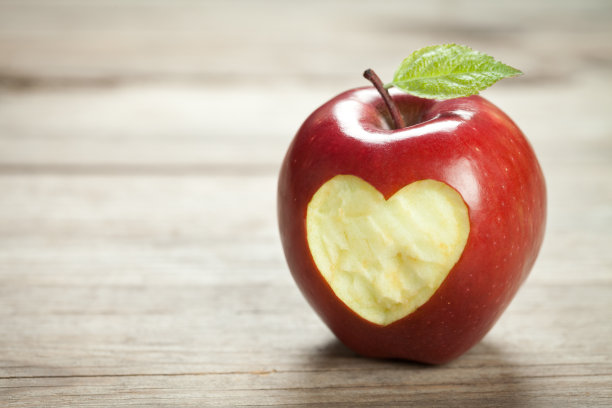 带心形的苹果放在旧木桌上图片下载