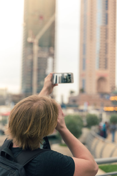 年轻人在阿拉伯联合酋长国迪拜码头拍摄建筑物图片下载