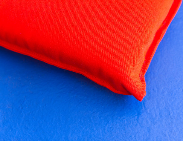 充满活力的橙色枕头在天蓝色的表面图片下载