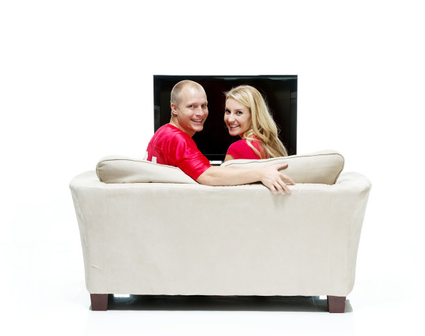 一对幸福的情侣坐在沙发上看着镜头图片下载