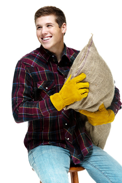 快乐的年轻人坐在凳子上与粗麻袋图片下载