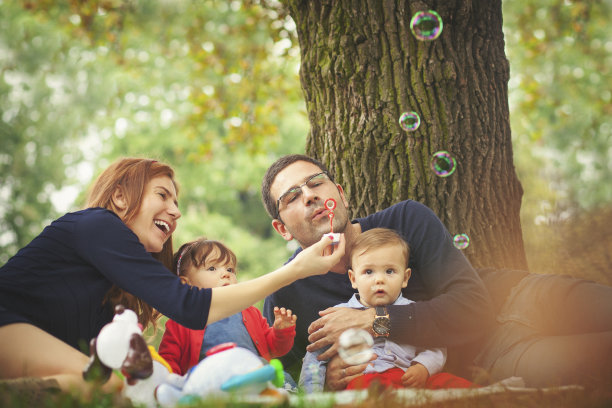 快乐的家庭玩着肥皂泡图片下载