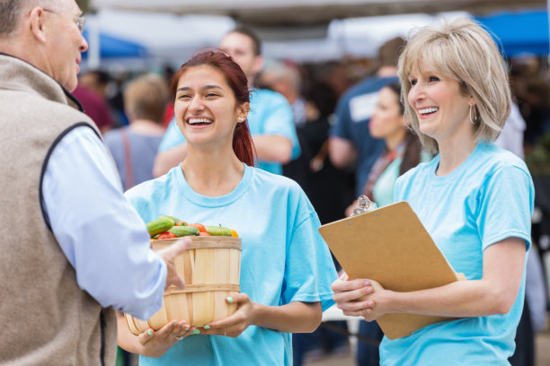 农产品摊位工作人员在农贸市场与顾客交谈图片下载