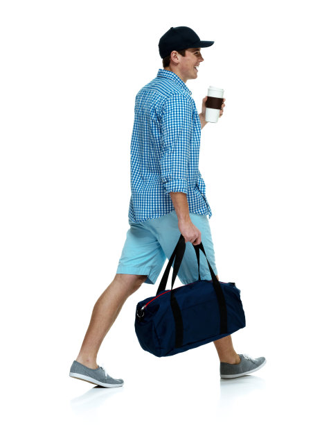 微笑随意的男人拿着运动包走着图片下载