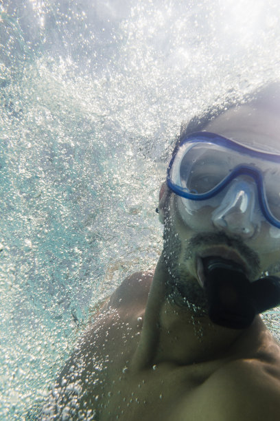 男子在清澈的水中浮潜图片下载