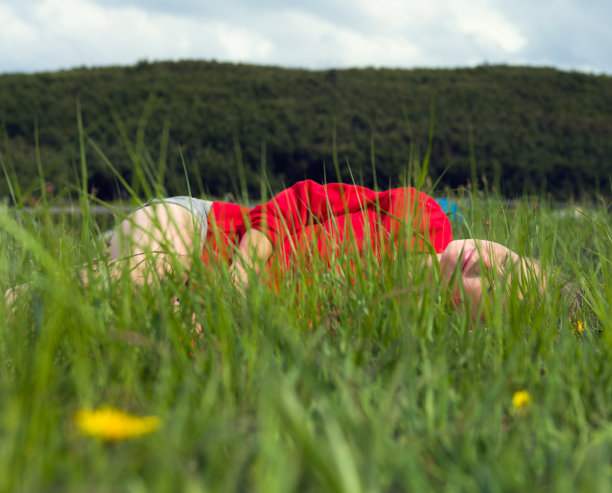 一位年轻女子正在草地上休息图片下载