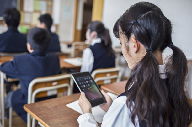 一名日本女孩在学校用平板电脑工作。图片下载