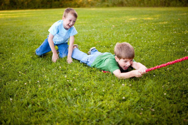 男孩们在外面玩拔河时开怀大笑图片下载