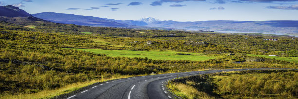 乡村道路弯弯曲曲向下进入绿色的山谷农场村庄全景图片下载