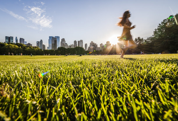 女孩在中央公园曼哈顿天际线前奔跑图片下载