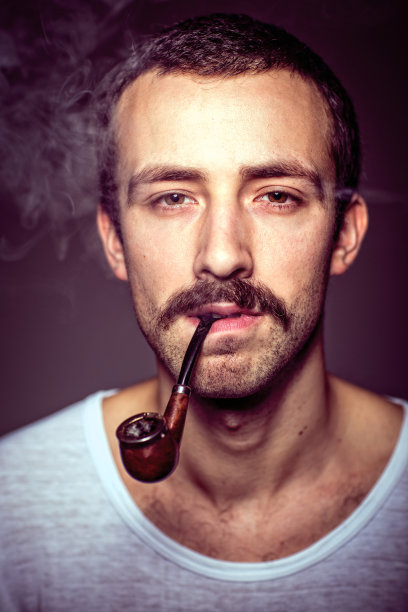 一个留着小胡子，拿着烟斗的男人的肖像图片下载