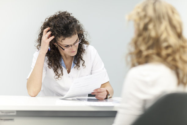 忧心忡忡的女医生阅读病人的医疗记录图片下载